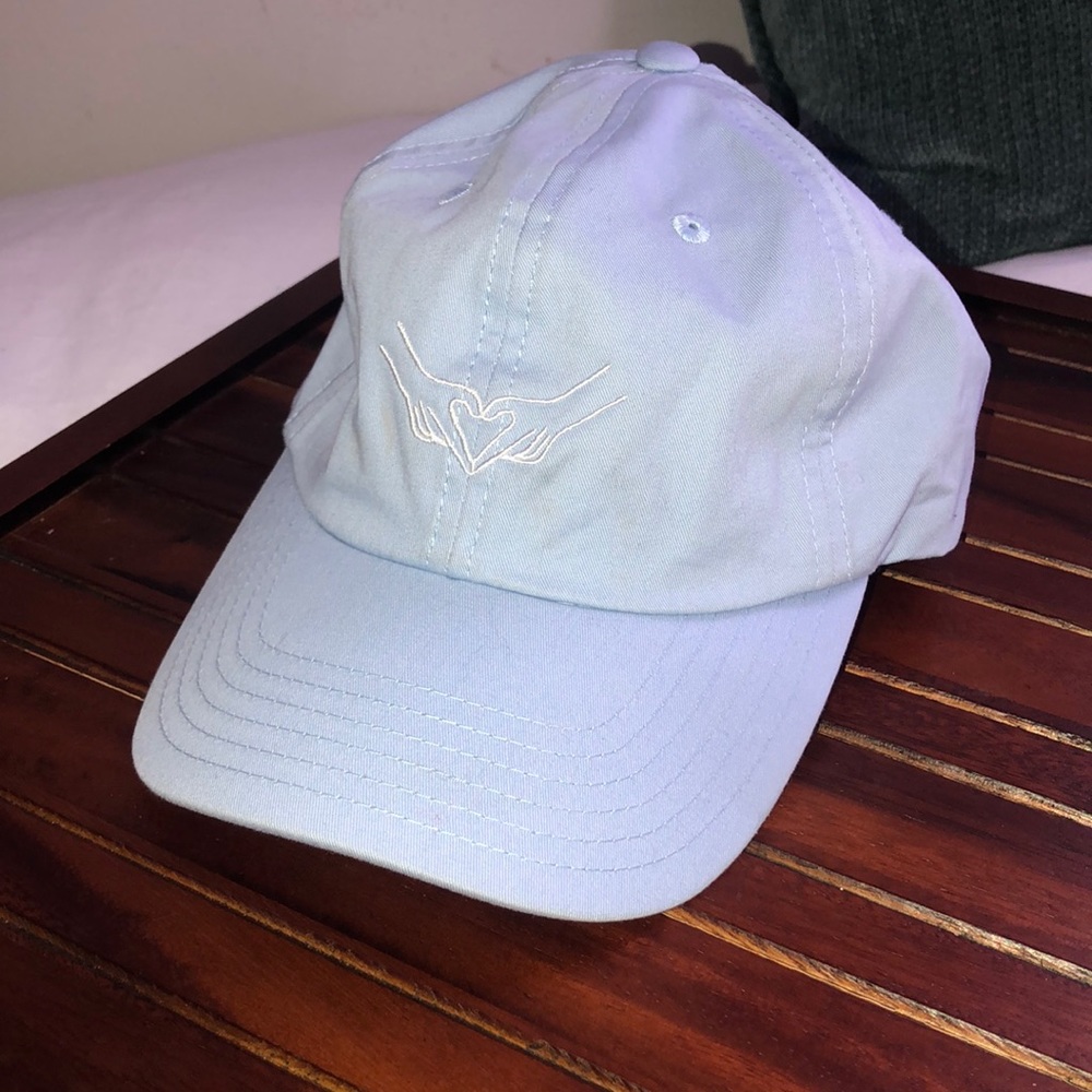 Baby blue hat, hands and heart logo